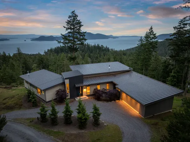 Modern home with metal roof overlooking mountain vista