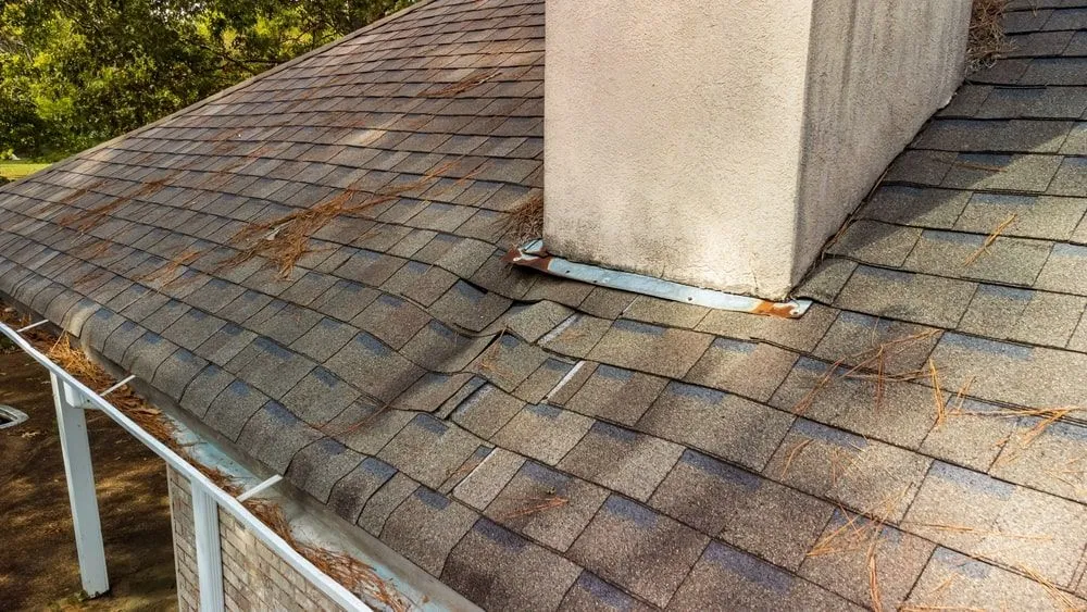 Rusty roof flashing with visible damage around chimney