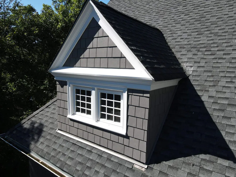 Gray shingle roof with dormer window and white trim